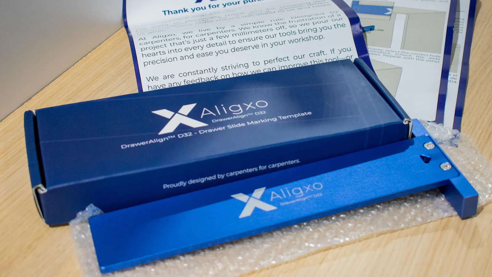 DrawerAlign D32 next to its box, thank-you letter and bilingual user guide